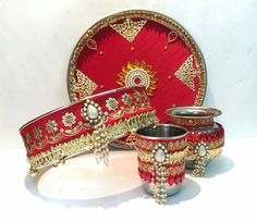 three pieces of red and gold decorated items