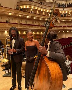 two men standing next to each other in front of a musical instrument and an orchestra