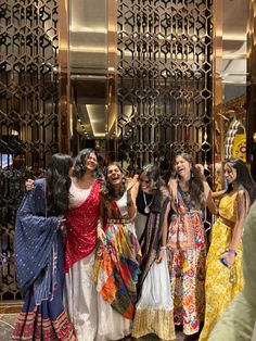 several women are standing in front of a mirror