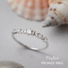 a close up of a ring on a table with shells and seashells in the background