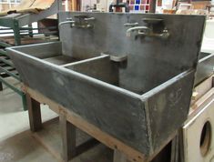 an old metal sink sitting on top of a wooden table