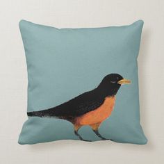 a black and orange bird sitting on top of a blue pillow with a white back ground