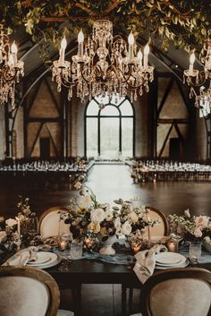 an elegant wedding reception with chandeliers and tables set up for the guests to eat