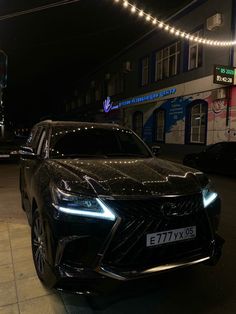 a black car is parked on the street at night