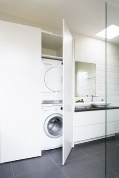 a white washer and dryer in a room with black tile on the floor