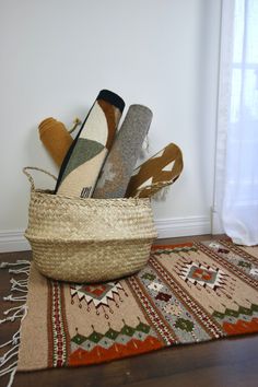 a basket filled with socks sitting on top of a wooden floor next to a rug