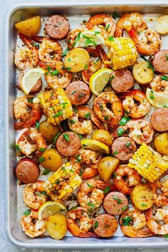 a pan filled with shrimp, corn and potatoes