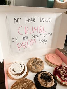 a box filled with lots of different flavored donuts next to a sign that says my heart would crumble if you didn't go to prom me