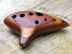 a wooden object sitting on top of a wooden table with holes in the middle of it