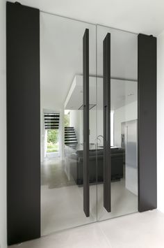 an empty room with black and white decor on the walls is reflected in glass doors