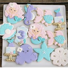 there are many decorated cookies on the plate with little mermaids and seahorses