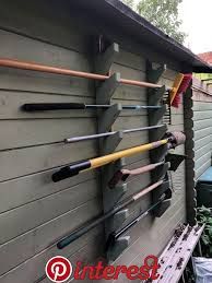 there are many different types of garden tools on the wall in front of this house