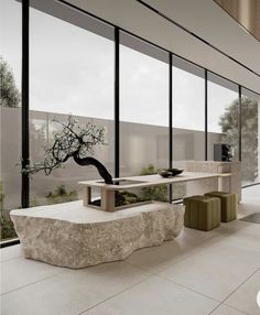 a living room with large windows and a bonsai tree