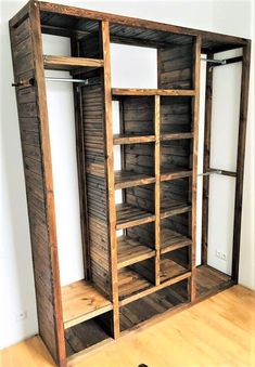 an empty closet with wooden shelves and shelving unit in the corner, on hard wood flooring