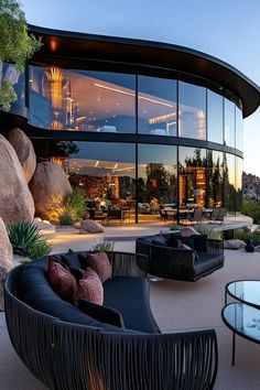 an outdoor living area with black furniture and large windows