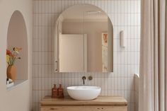 a bathroom sink sitting under a mirror next to a window