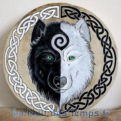 a black and white wolf with green eyes painted on a wooden plate in the shape of a circle