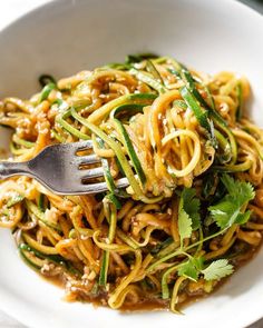 a white bowl filled with noodles and vegetables