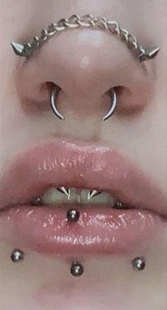 a woman's lips with piercings on them