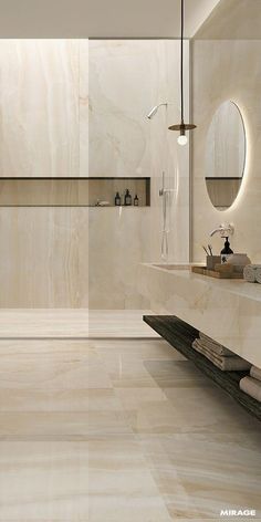 a modern bathroom with marble walls and flooring, including a large mirror on the wall