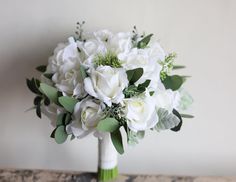 a bouquet of white flowers sitting on top of a table