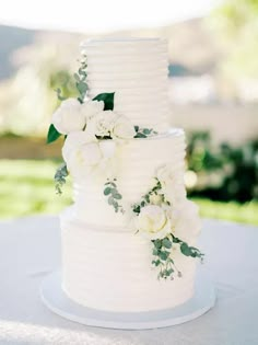 a wedding cake with white flowers and greenery