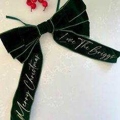 a green bow with writing on it and two cherries