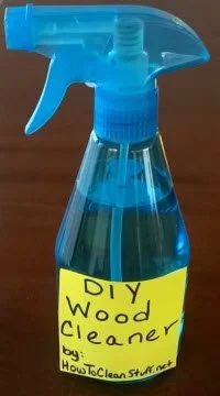 a bottle of diy wood cleaner sitting on top of a wooden table next to a yellow sticker