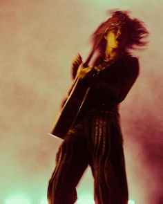 a man with long hair standing on stage