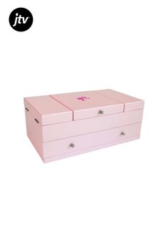 a pink jewelry box sitting on top of a white surface with the lid open and two drawers closed