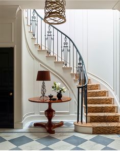 a table with flowers on it in front of a staircase