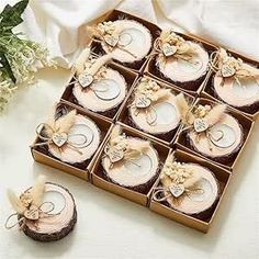 a box filled with cupcakes sitting on top of a white cloth covered table