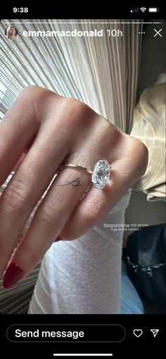 a woman's hand with a ring on it and a diamond in the middle