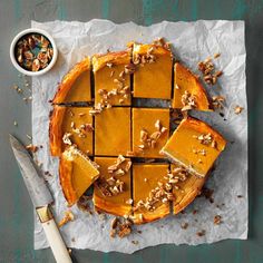 sliced pumpkin pie with walnuts and pecans on top, ready to be eaten