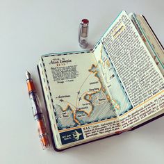 an open book with a map and pen next to it