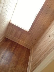 an empty room with wood floors and a skylight in the corner on the wall