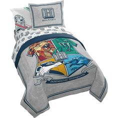 a bed with a cartoon character on the cover and pillow cases in grey, blue, yellow and white