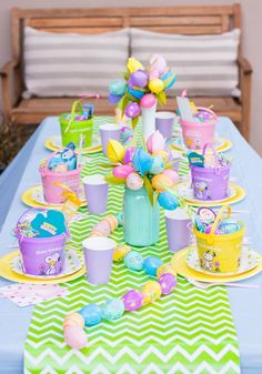 the table is set up with cups and plates for an easter egg hunt or party