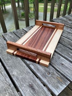 a wooden cutting board sitting on top of a picnic table