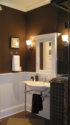 a white sink sitting under a bathroom mirror next to a walk in shower and toilet