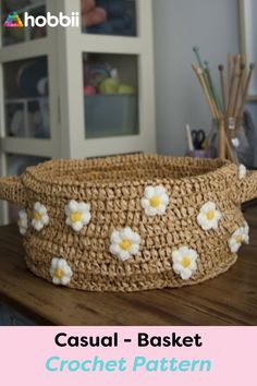 a basket with flowers on it sitting on top of a wooden table next to other items