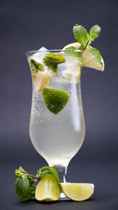 a tall glass filled with ice and lime