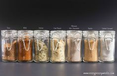 seven jars filled with different types of spices