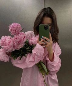 a woman taking a selfie in front of a mirror with pink flowers on it