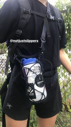 a man wearing black shorts and carrying a white soccer ball in his back pack with the words, not just slippers on it