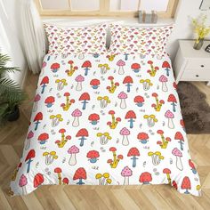 a bed with colorful mushrooms on it in a room next to a potted plant