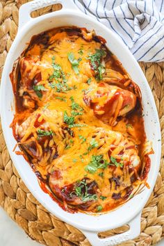 a white casserole dish filled with chicken, cheese and cilantro sauce