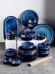 a blue dinnerware set with chopsticks and plates