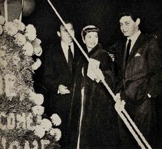 an old black and white photo of two men cutting a cake