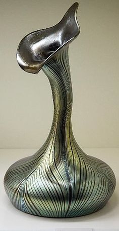 a silver vase sitting on top of a white table